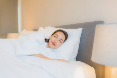 Asyalı güzel bir kadının portresi. Gülümse. Yatak odasında rahatla.