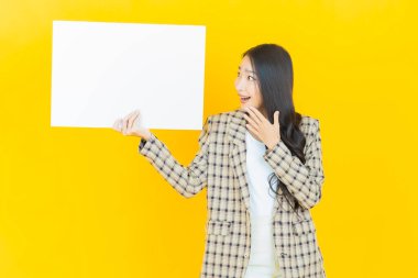 Renkli arka planda boş beyaz ilan panosu olan güzel Asyalı kadın portresi