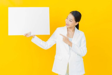 Renkli arka planda boş beyaz ilan panosu olan güzel Asyalı kadın portresi