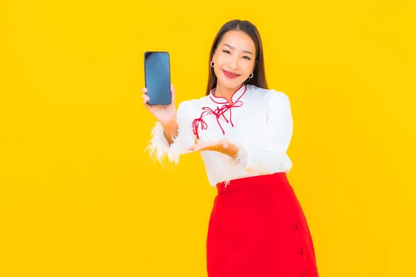 Portret Pięknej Młodej Azjatyckiej Kobiety Smartfonem Żółtym Tle — Zdjęcie stockowe