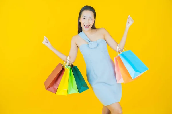肖像画美しい若いアジアの女性の笑顔でショッピングバッグ上の色の背景 — ストック写真