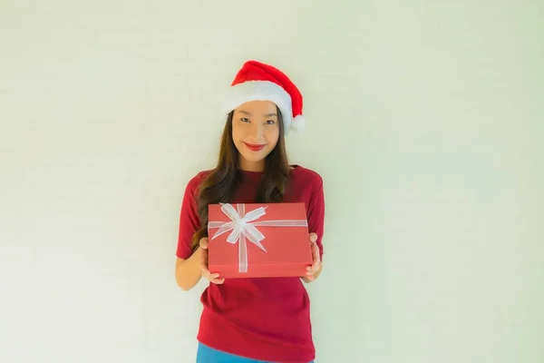 肖像画の美しい若いアジアの女性はお祝いのためのギフトボックスとクリスマスフェスティバルでサンタの帽子を着用 — ストック写真
