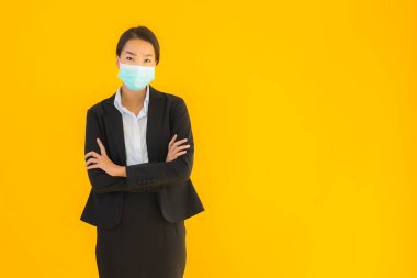 Güzel genç iş kadını portresi Korunmak için maske takıyor 19 koronavirüs sarı izole arka planda