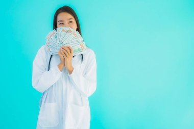 Güzel Asyalı genç doktor kadın portresi. Mavi izole edilmiş arka planda bir sürü parası ve parası var.