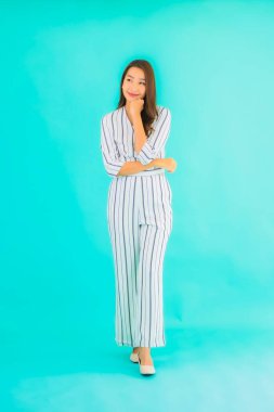 Asyalı güzel bir kadının portresi mavi izole edilmiş arka planda gülümsüyor.