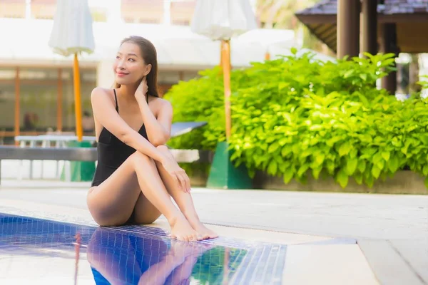 아름다운 아시아 여성은 리조트 수영장에서 여가를 보내며 미소짓는다 — 스톡 사진