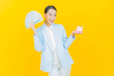 Renkli arka planda domuz kumbarası olan güzel Asyalı kadın portresi