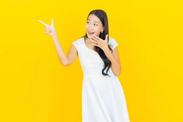 肖像美しい若いアジアの女性の笑顔アクションで黄色の色の背景 — ストック写真