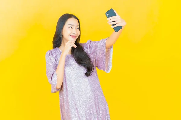아름다운 아시아 여성의 초상화 배경에 스마트폰을 미소짓는 — 스톡 사진