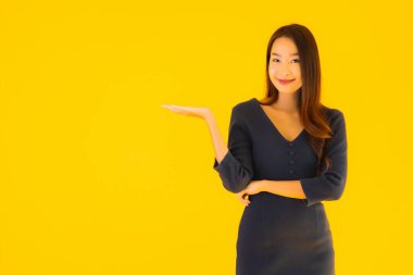 İzole edilmiş sarı arka planda hareketli güzel Asyalı kadın portresi.