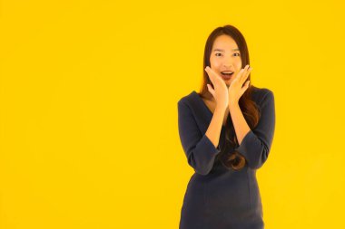 İzole edilmiş sarı arka planda hareketli güzel Asyalı kadın portresi.