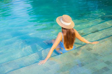 Güzel bir Asyalı kadın portresi. Rahatlayın. Yüzme havuzunun, deniz kenarındaki okyanus manzarasının keyfini çıkarın.