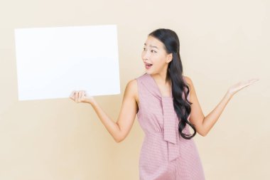 Renkli arka planda boş beyaz ilan panosu olan güzel Asyalı kadın portresi