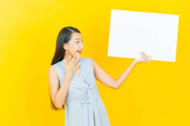 Renkli arka planda boş beyaz ilan panosu olan güzel Asyalı kadın portresi