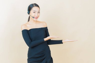 Sarı arka planda çağrı merkezi müşteri hizmetleri merkezi olan güzel Asyalı kadın portresi