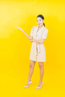 Portre güzel Asyalı kadın gülümsüyor. Renkli arka planda hareket var.