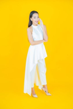 Portre güzel Asyalı kadın gülümsüyor. Renkli arka planda hareket var.