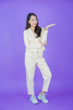 Portre güzel Asyalı kadın gülümsüyor. Renkli arka planda hareket var.