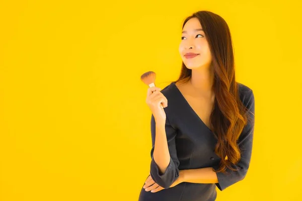 Portrait Beautiful Young Asian Woman Makeup Brush Yellow Isolated Background — Stock Photo, Image