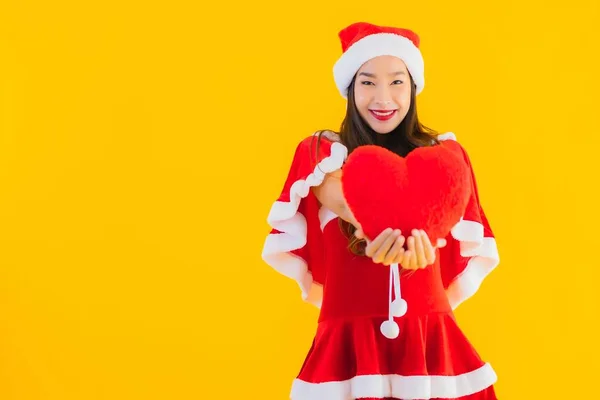 年轻美丽的亚洲圣诞服装和帽子在黄色孤立的背景下 带着心形的笑容 — 图库照片