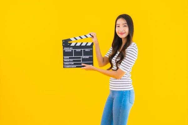 肖像美しい若いアジアの女性ショークラッパームービーボード上の黄色隔離された背景 — ストック写真