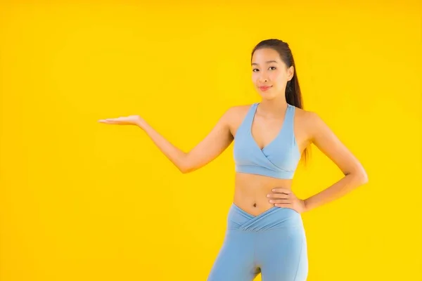 穿着运动鞋的年轻貌美的亚洲女运动员 准备在黄色孤立的背景下进行锻炼 — 图库照片