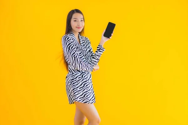Portré Gyönyörű Fiatal Ázsiai Okos Mobiltelefon Hitelkártya Sárga Elszigetelt Háttér — Stock Fotó