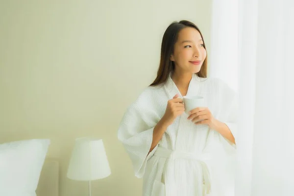 寝室のインテリアでコーヒーカップと肖像画の美しい若いアジアの女性 — ストック写真