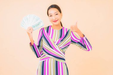 Parası, parası ve cep telefonu olan güzel Asyalı bir kadının portresi.