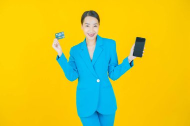 Güzel bir Asyalı kadının portresi. Renkli kredi kartıyla gülüyor.