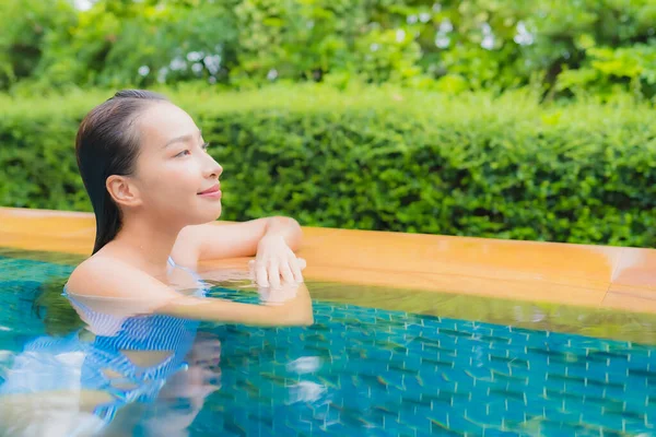 美しい若いアジアの女性の肖像旅行休暇のためのホテルのリゾートでスイミングプールの周りの笑顔をリラックス — ストック写真