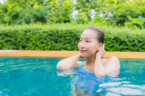 美しい若いアジアの女性の肖像旅行休暇のためのホテルのリゾートでスイミングプールの周りの笑顔をリラックス — ストック写真