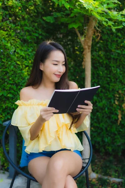 年轻的亚洲女人阅读关于室外花园自然景观的书籍 — 图库照片