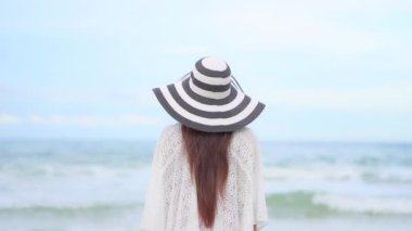 Yaz tatilinde deniz kıyısındaki Asyalı kadının görüntüleri.