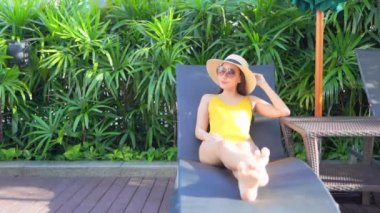 Güzel bir Asyalı kadın portresi. Otel havuzunun yanında güneşlenir.