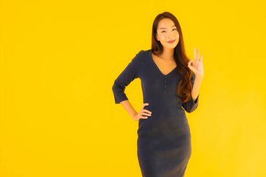 İzole edilmiş sarı arka planda hareketli güzel Asyalı kadın portresi.