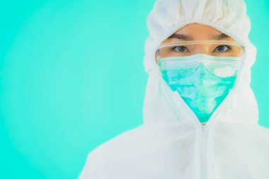 Güzel, genç Asyalı doktor kadın portre. Koronavirüsten ya da mavi arka planda kovid19 'dan korunmak için ppe ya da kişisel koruyucu ekipman takıyor.