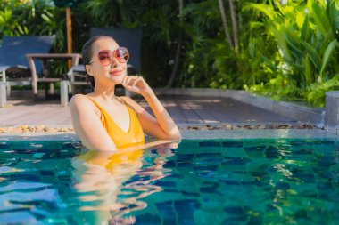 Güzel bir Asyalı kadın portresi. Rahatlayın. Keyifli bir tatil için oteldeki yüzme havuzunda mutlu bir gülümseme.