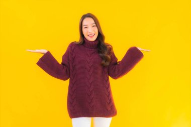 Güzel Asyalı kadın gülümsüyor. Sarı izole edilmiş arka planda başka bir eylemde mutlu.