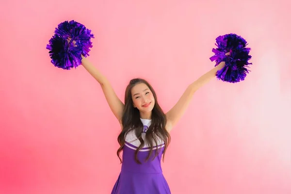年轻美丽的亚裔女子啦啦队队长笑着 带着淡淡的粉红背景 — 图库照片