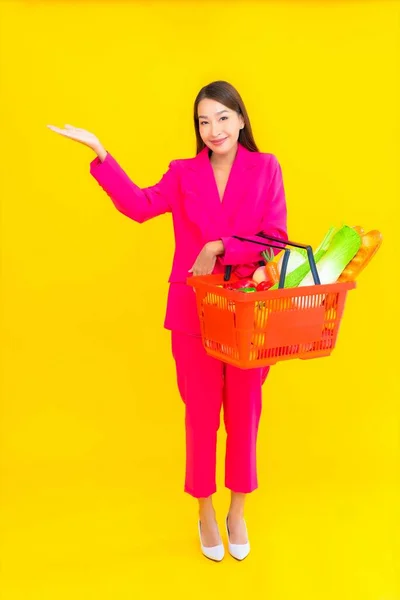 천연색 배경으로 슈퍼마켓에서 바구니나 식료품을 가지고 아름다운 아시아 여인의 — 스톡 사진