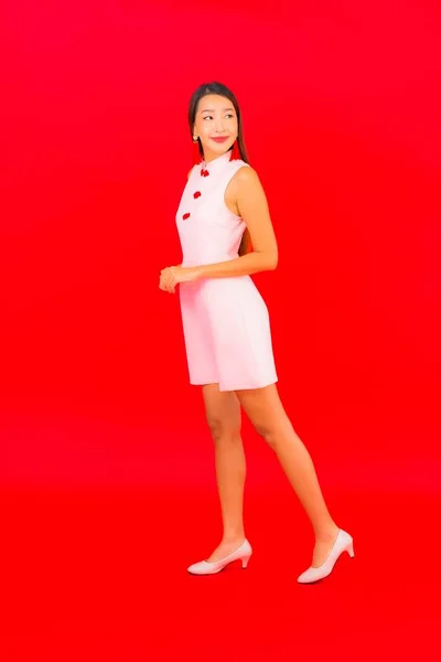 亚洲年轻貌美的女子穿着红色背景的中国新年服装 — 图库照片