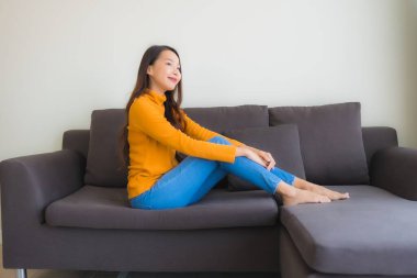 Genç Asyalı kadının portresi mutlu. Rahat ol. Koltukta gülümse.