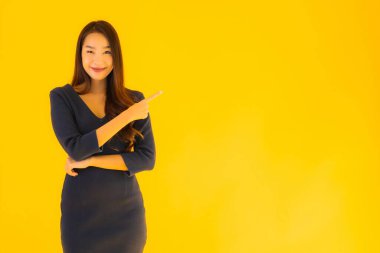 İzole edilmiş sarı arka planda hareketli güzel Asyalı kadın portresi.