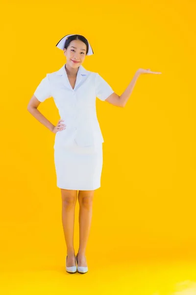 노란색외진 배경에 클리닉 병원에서 환자를 활동을 아름다운 이시아 계젊은 간호사의 — 스톡 사진