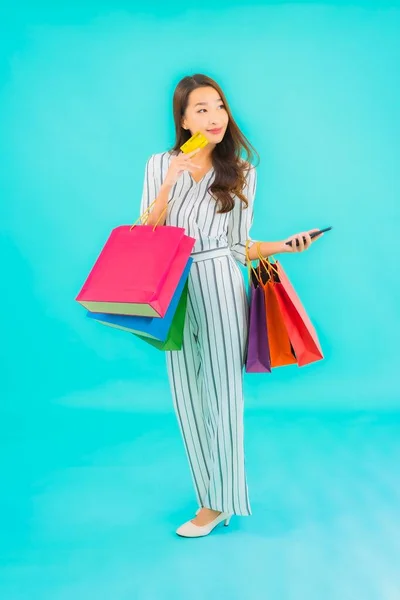 亚洲年轻貌美的女人 蓝色背景的购物袋 — 图库照片