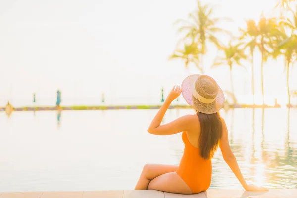 美丽的年轻亚洲女人在日落时分 在海滩附近的室外游泳池边 放松地笑着 享受假期 — 图库照片
