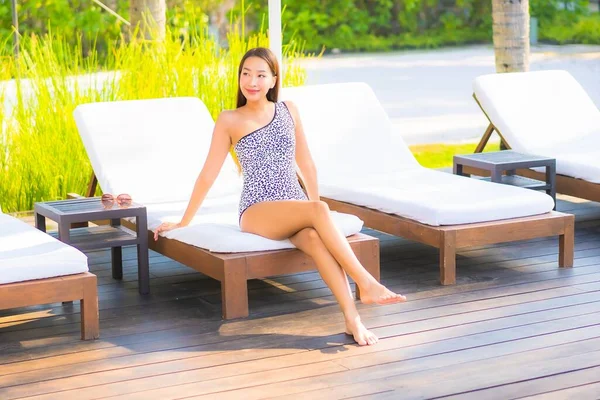 Güzel bir Asyalı kadın portresi. Rahatlayın, gülümseyin. Tatil için oteldeki yüzme havuzunun keyfini çıkarın.