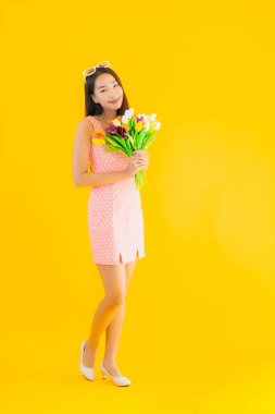 Sarı izole edilmiş arka planda renkli çiçekli güzel Asyalı kadın portresi.