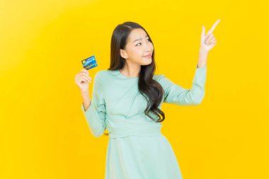 Güzel bir Asyalı kadının portresi. Renkli kredi kartıyla gülüyor.